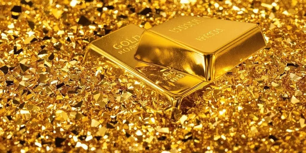Two gold bars resting on a bed of glittering gold flakes